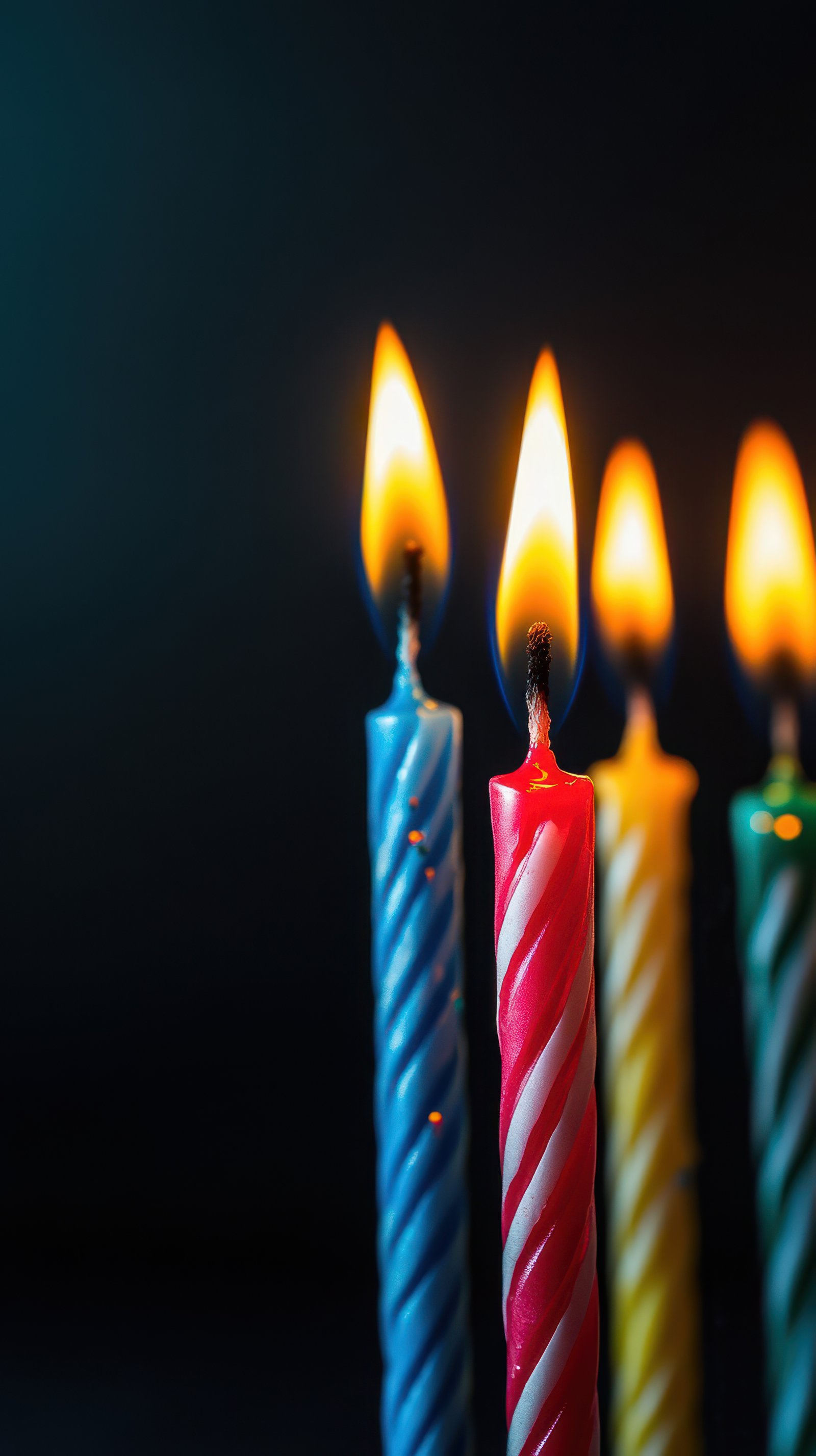 Colorful birthday candles glowing on a dark background during a festive celebration